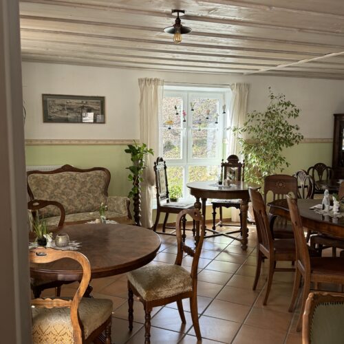 Gemütlicher Innenraum mit Sitzgruppen und Sofa im Café des Lebens