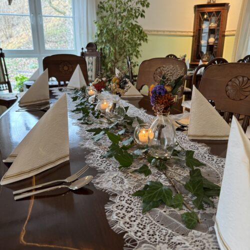 Liebevoll gedeckter Tisch mit Blumen und Dekoration im Café des Lebens