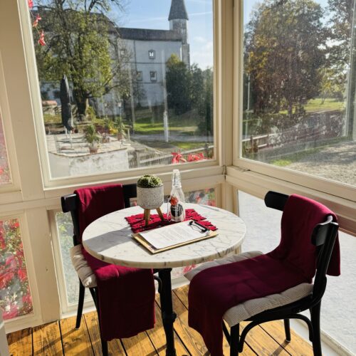 Gemütlicher Sitzbereich im Café mit Blick nach draußen auf das Schloss