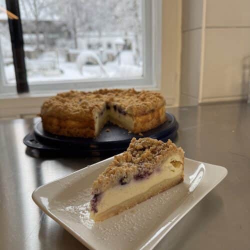 Stück hausgemachter Kuchen auf einem Teller am Fenster mit Blick nach draußen