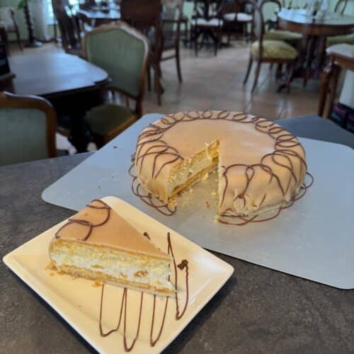 Hausgemachter Kuchen mit feiner Glasur und angeschnittenem Stück auf einer Platte