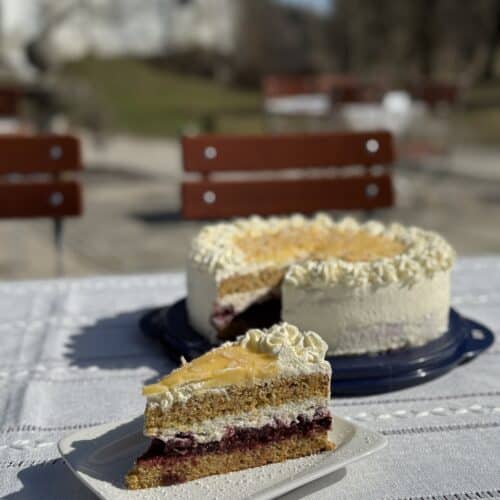 Stück hausgemachter Kuchen auf einem Teller im Außenbereich des Cafés