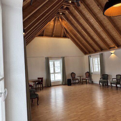 Großer Raum mit Holzdecke und offener Atmosphäre im Café des Lebens