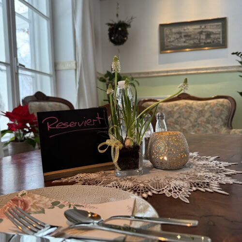 Gedeckter Tisch mit Reserviert Schild im gemütlichen Innenraum des Cafés