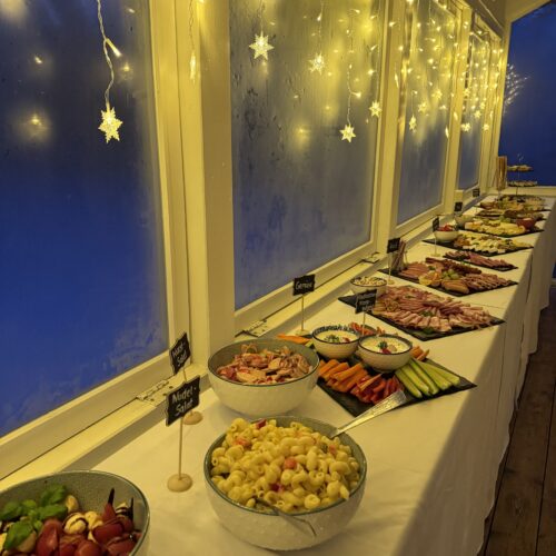 Großes Abendbuffet mit vielfältiger Auswahl und Lichterkette im Café