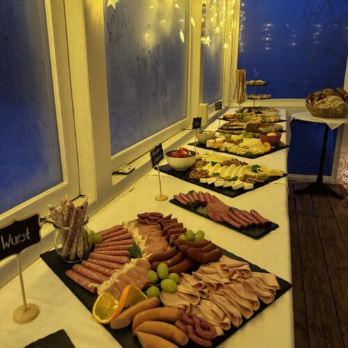 Abendbuffet mit Aufschnitt und warmem Licht im Café des Lebens