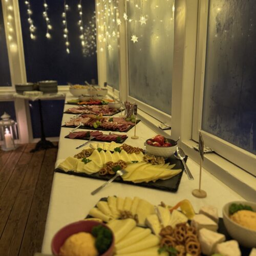 Abendliches Buffet mit Lichterkette und liebevoll angerichteten Speisen im Café